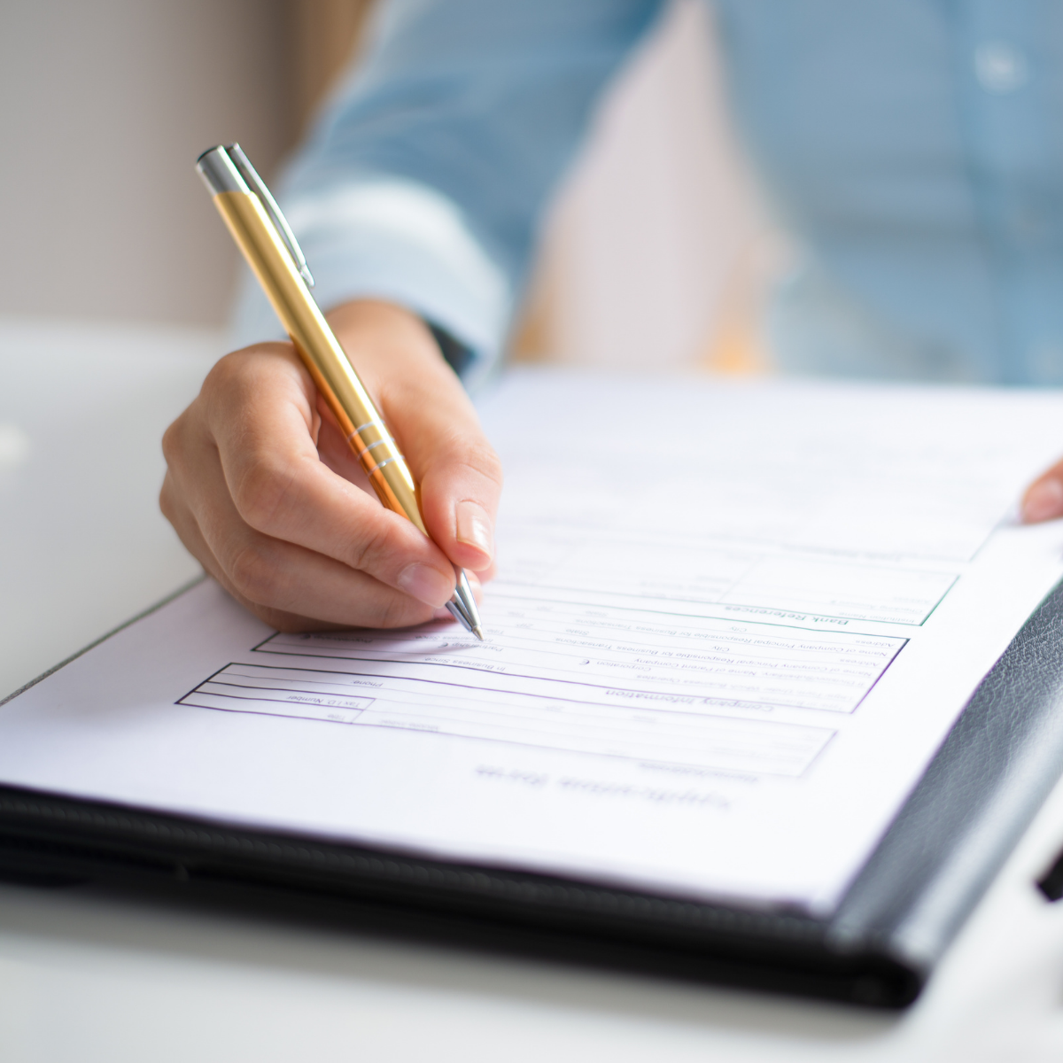 kobieta uzupełnia dane w papierowym formularzu