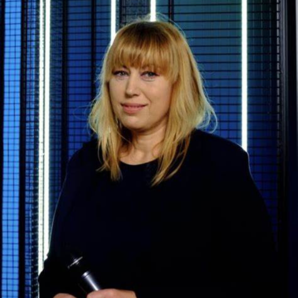 kobieta siedzi w czarnych ubraniach na niebieskim tle