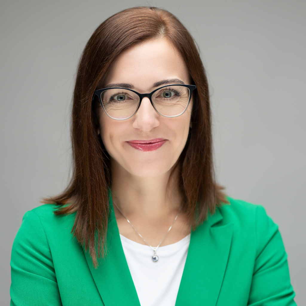 portret uśmiechniętej kobiety w okularach i zielonej marynarce