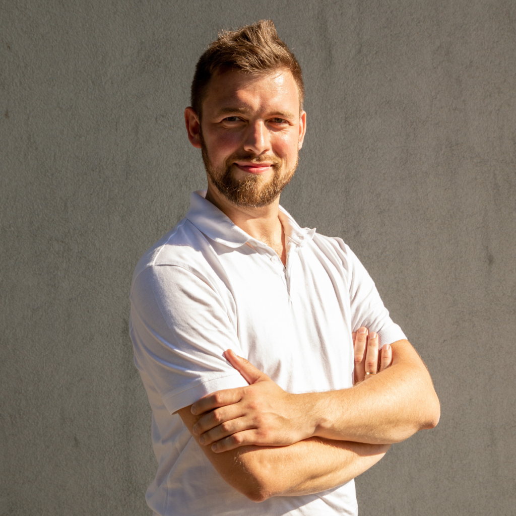 mężczyzna w koszulce polo stoi pewnie i się uśmiecha