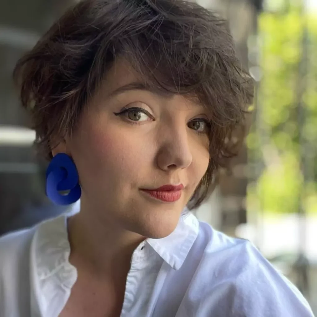 uśmiechnięta kobieta z dużymi niebieskimi kolczykami