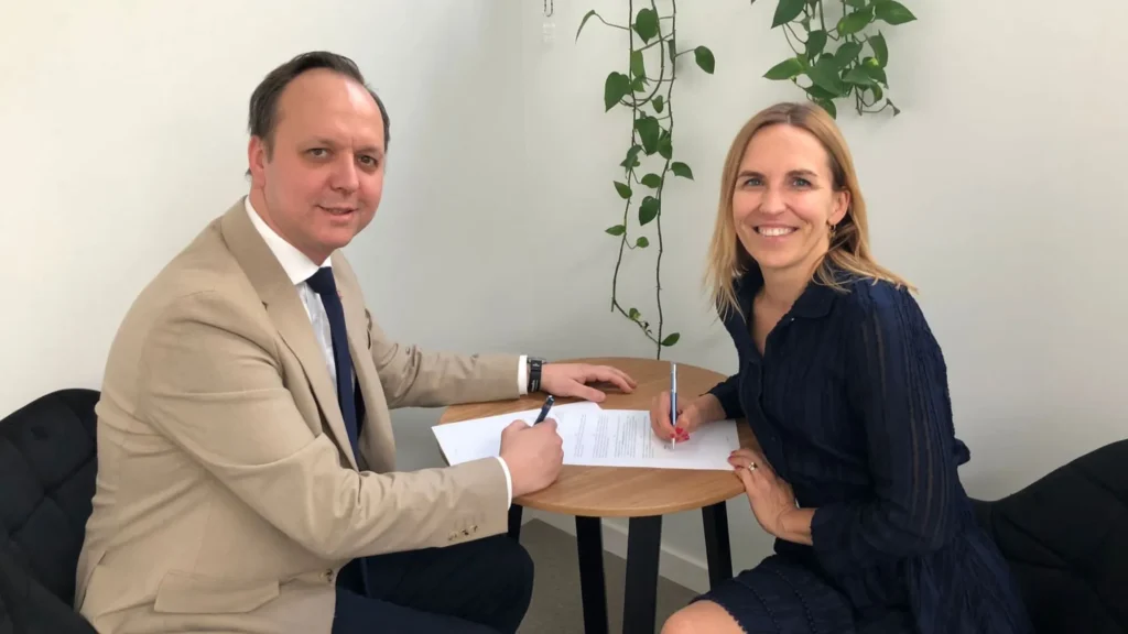 Monika Mardas-Brzezińska i Tomasz Mackiewicz podpisują list intencyjny siedząc przy stole