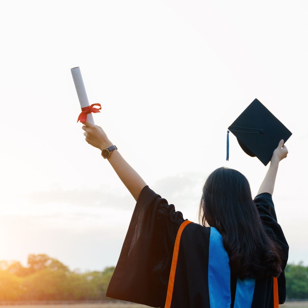 absolwent uczelni wyższej podnosi ręce w geście triumfu