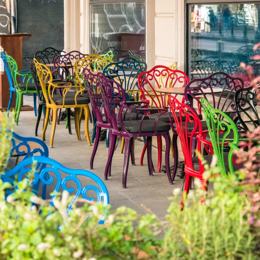 stoliki i kolorowe krzesła prawdopodobnie przed restauracją