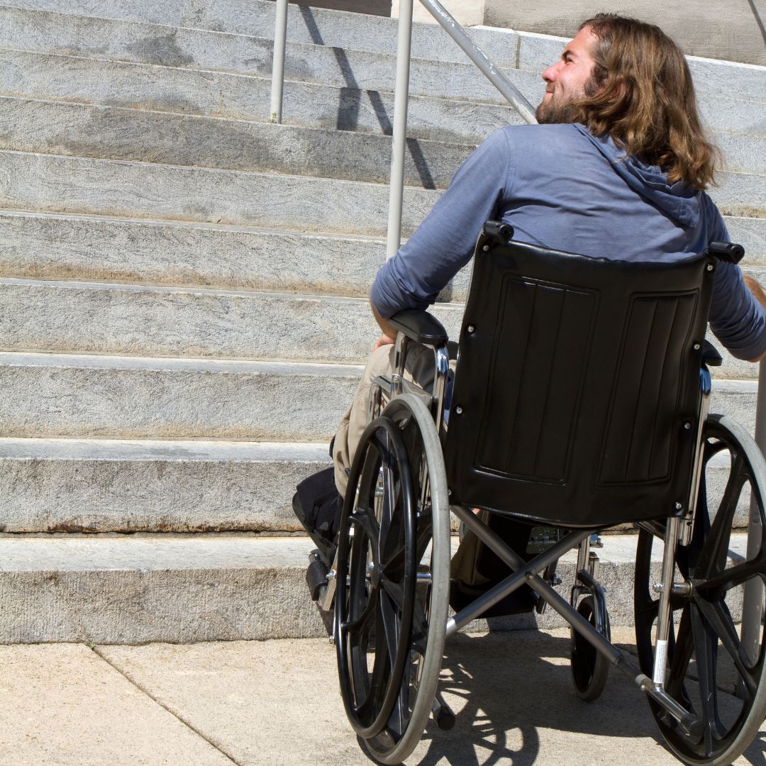 mężczyzna na wózku przed schodami