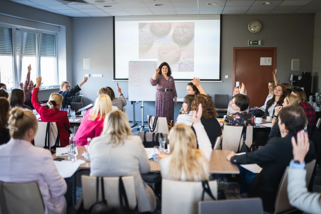 Grupa osób znajdujących się w sali i pracujących ze soba