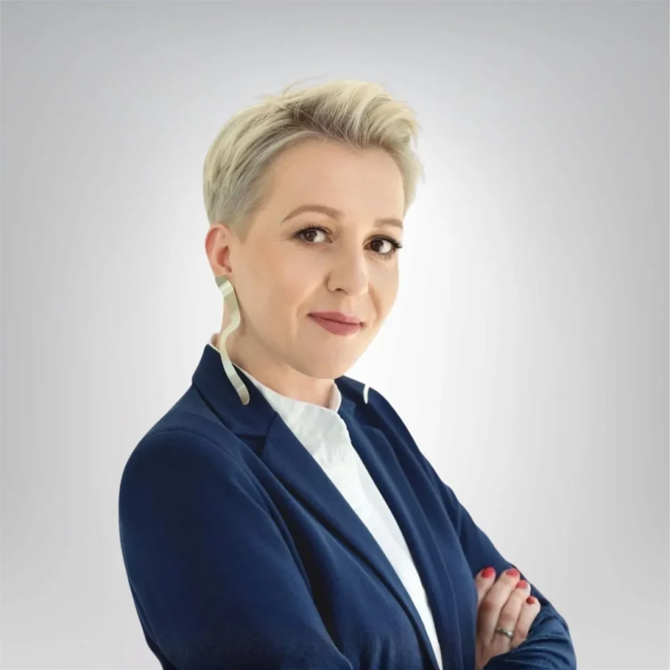 Kobieta w krótkich blond włosach i grantowej marynarce