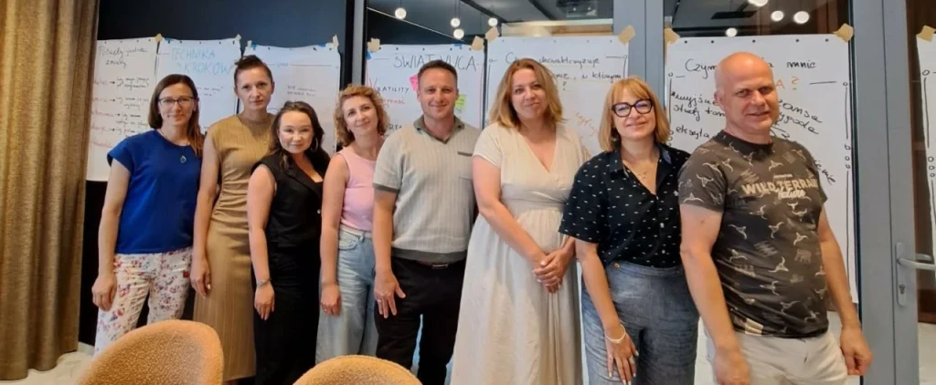 8 osób pozujących do grupowego zdjęcia