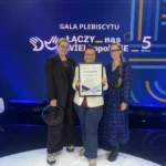 trzy usmiechniete kobiety na scenie trzymajace dyplom podziekowania na tle scianki gali plebiscytu „Łączy nas WIELkopolskiE 2026