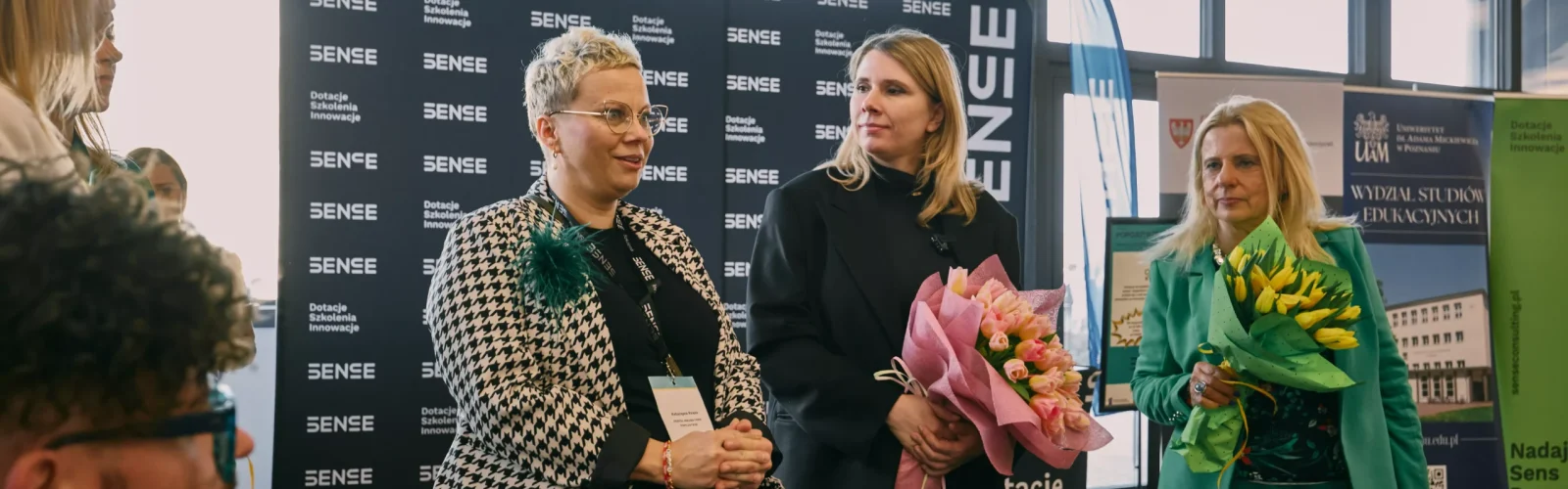 Kobiety stojące przy ściance SENSE